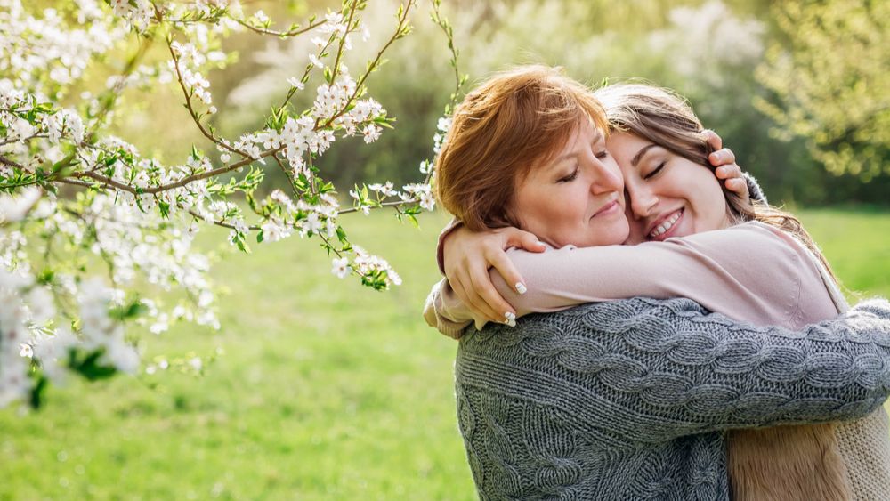 Two women hugging under flowering tree